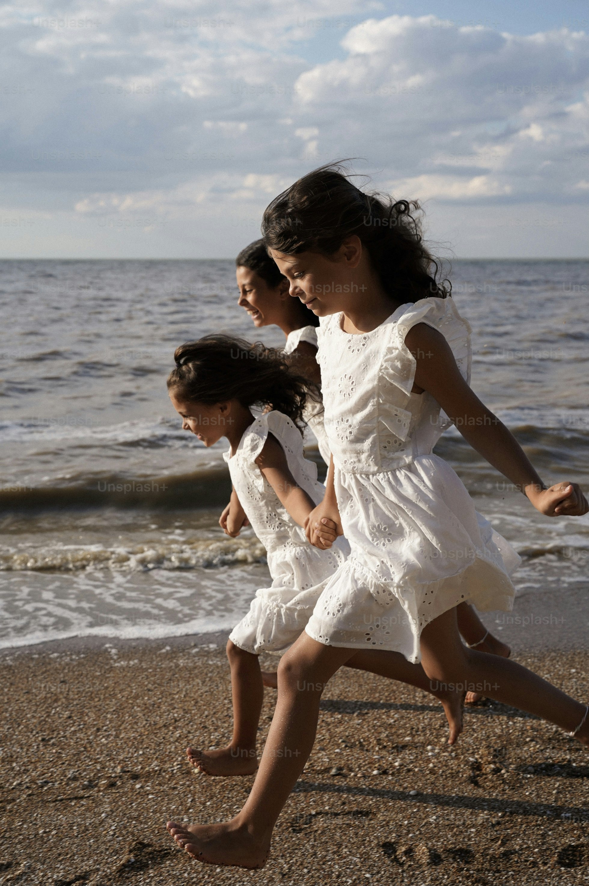 trois petites filles qui courent ensemble sur la plage