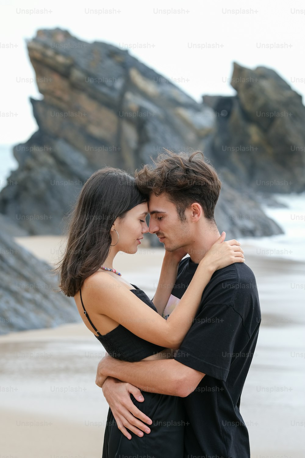 a man and a woman embracing on the beach