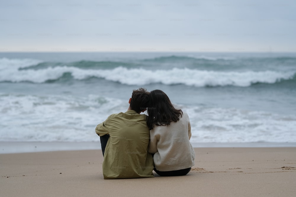 砂浜の上に座るカップル