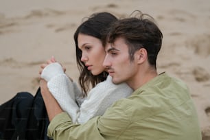 un homme et une femme assis sur la plage