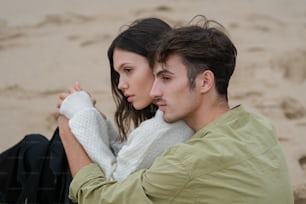 a man and a woman sitting on the beach