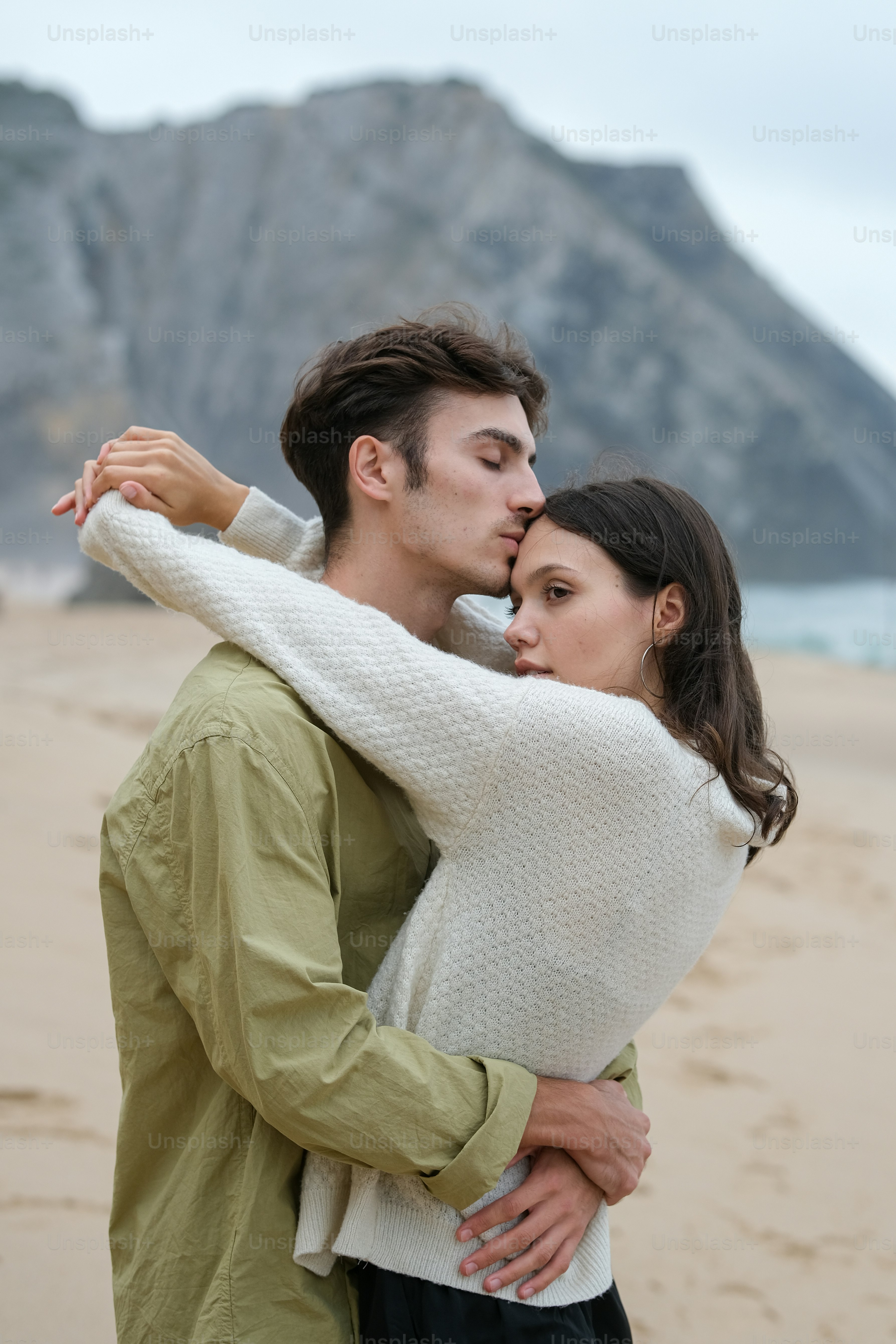 a man and a woman embracing on the beach