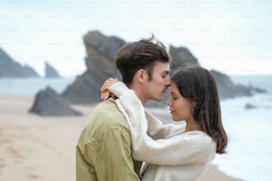 un homme et une femme debout l’un à côté de l’autre sur une plage