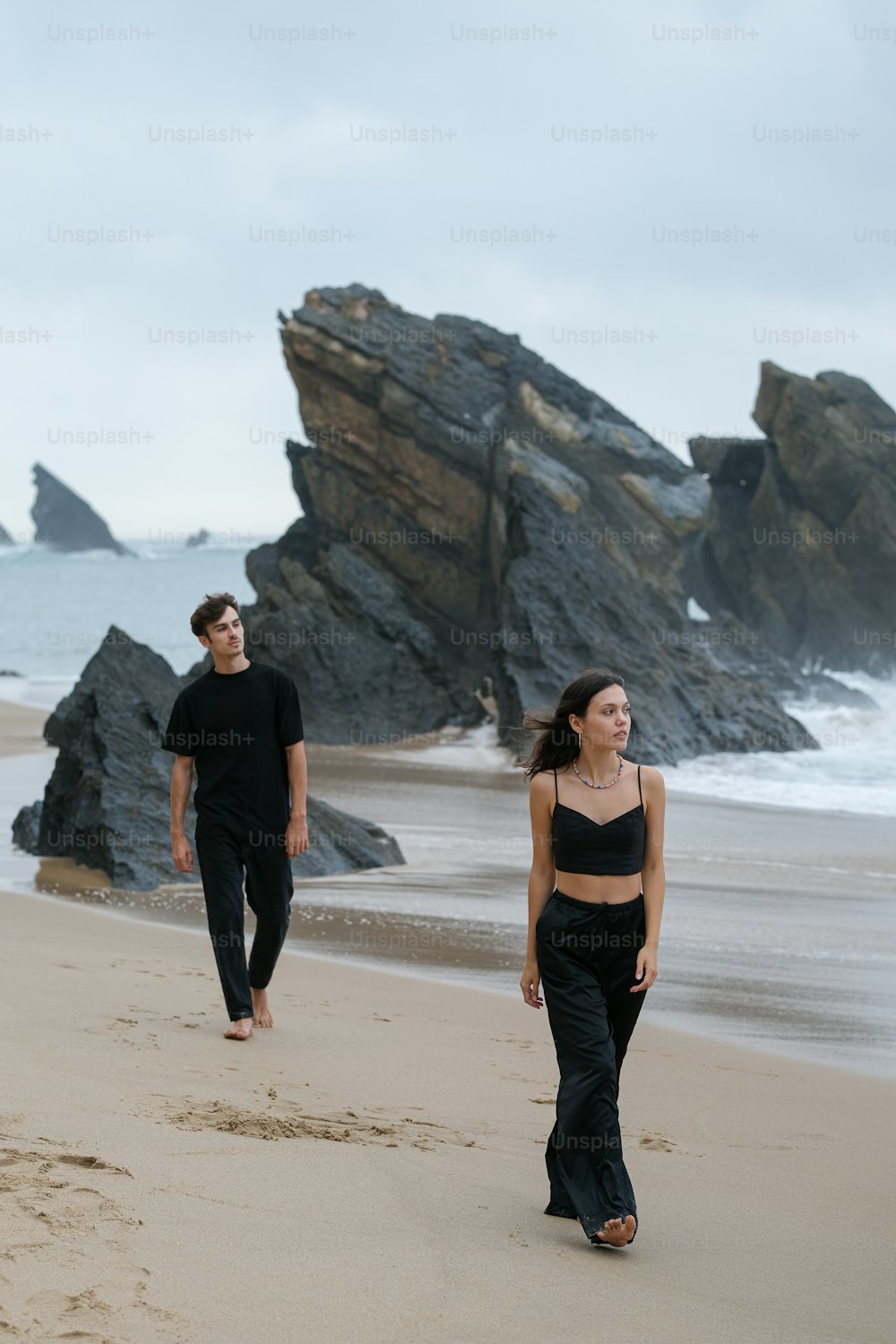 a man and a woman walking on a beach