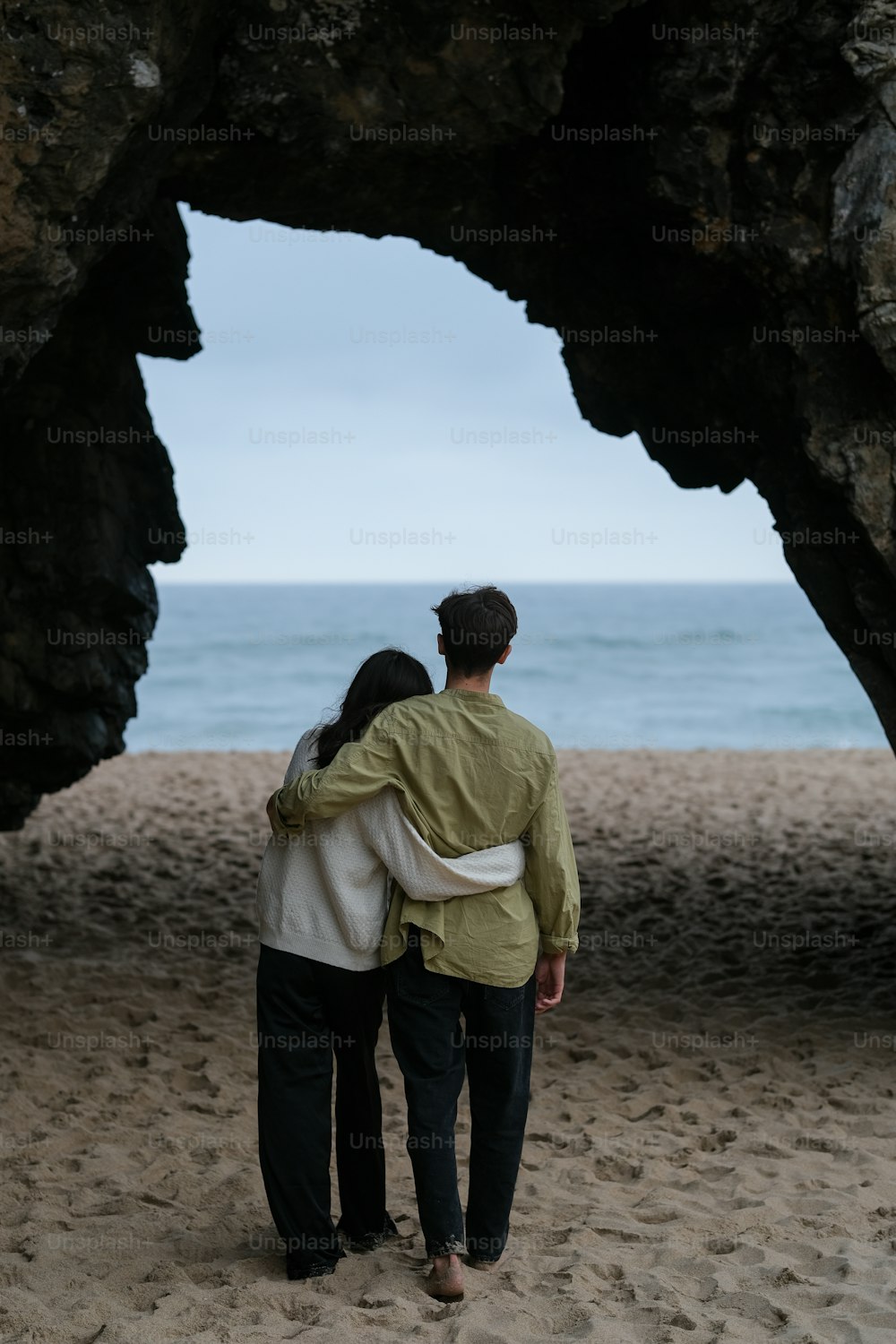 한 남자와 한 여자가 해변을 걷고 있다