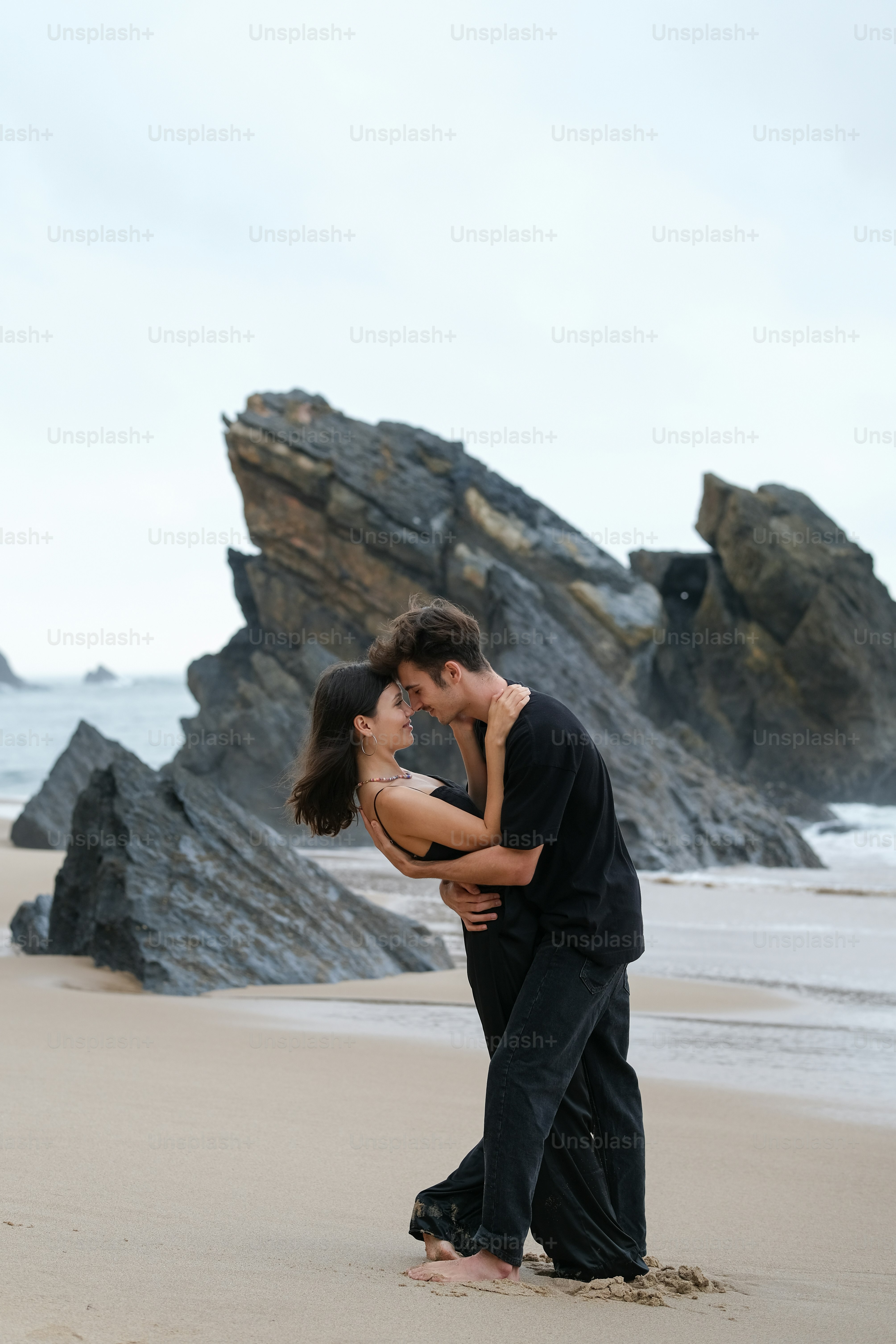 a man and a woman kissing on the beach