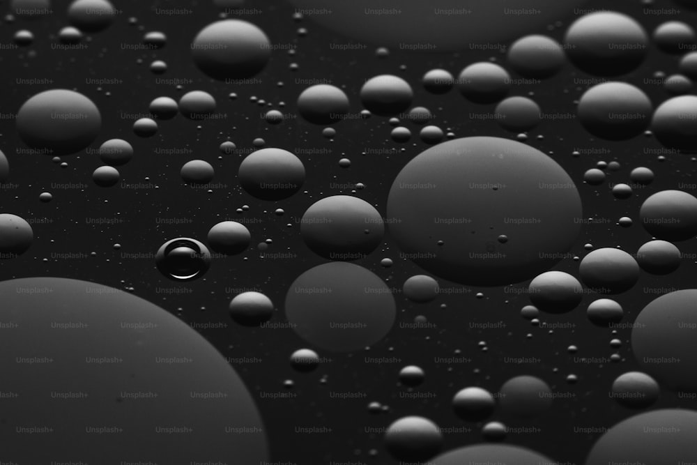 um monte de gotículas de água em uma superfície preta