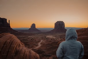 a person in a hoodie looking out at the desert