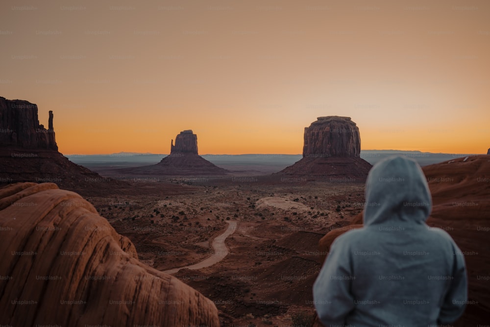 a person in a hoodie looking out at the desert