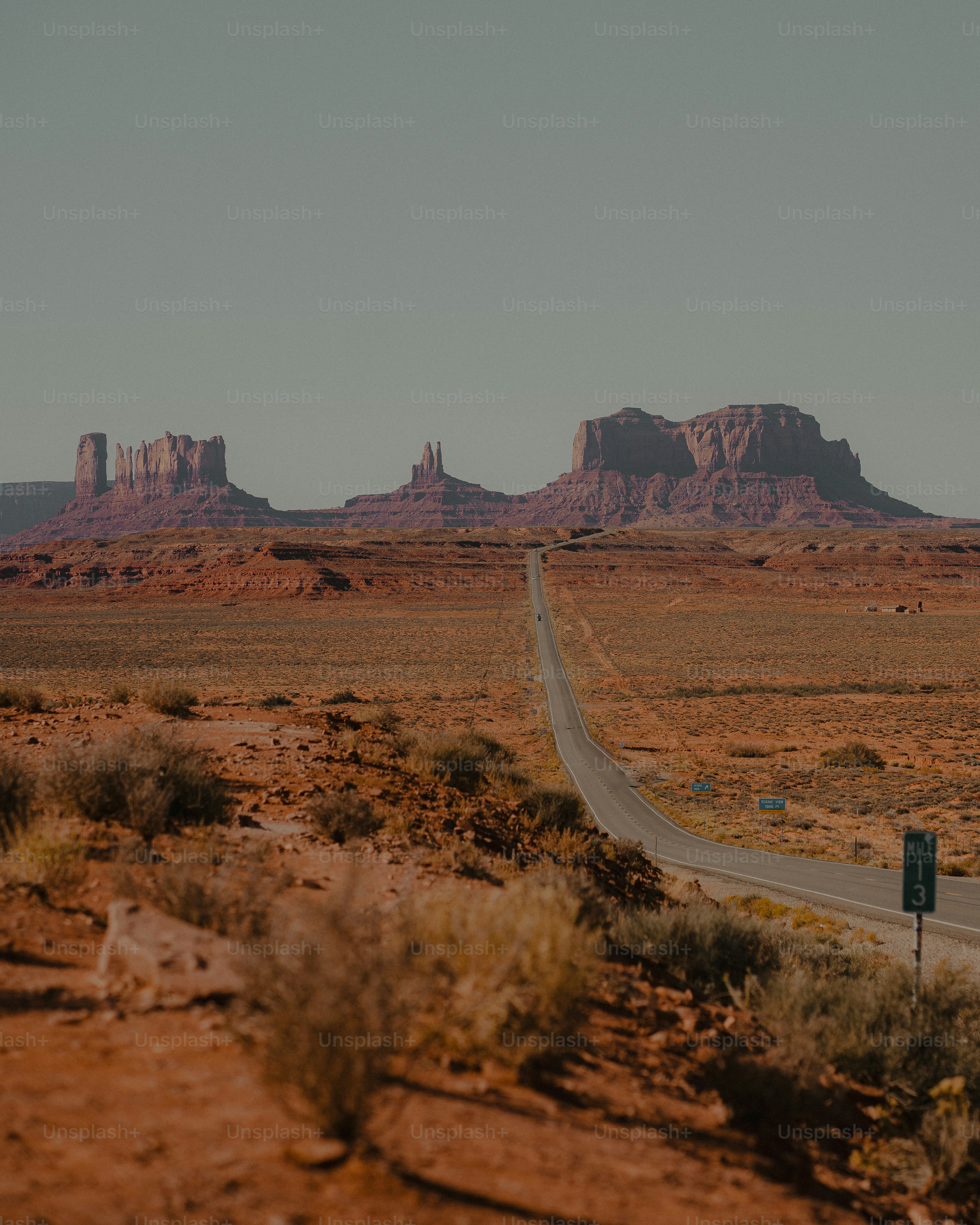 a road in the middle of a desert with mountains in the background