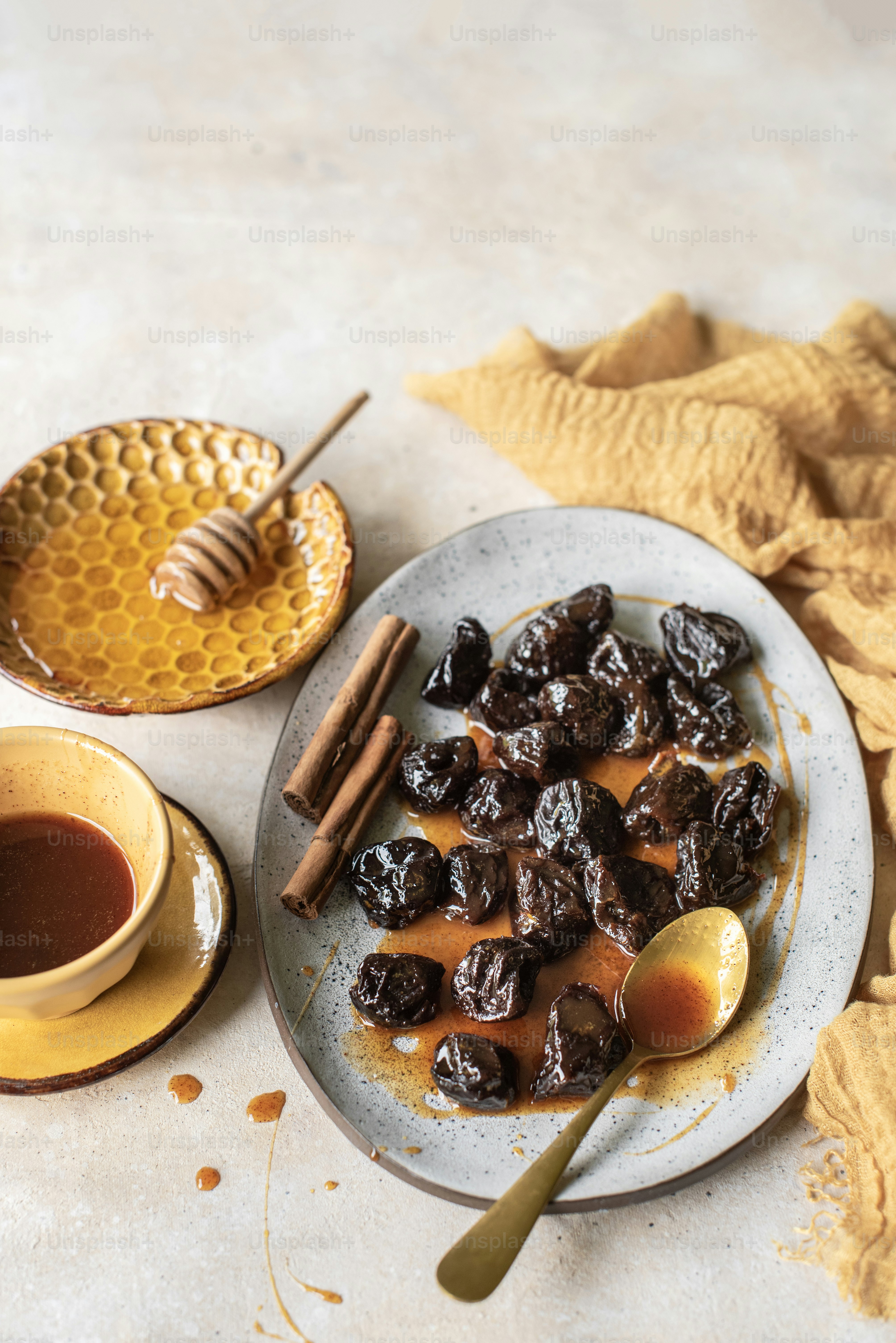 a plate of raisins and a bowl of honey