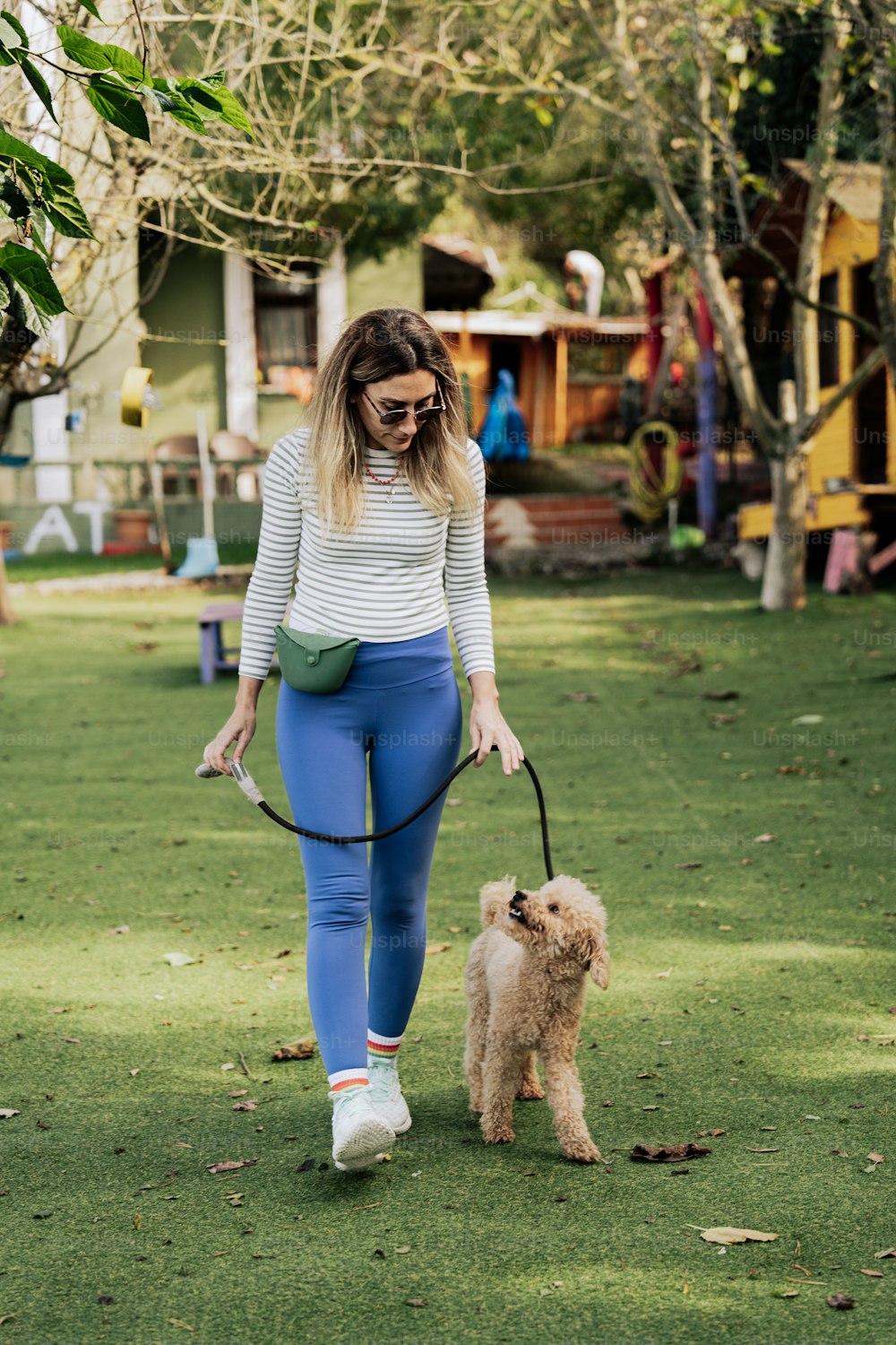 a woman walking a small dog on a leash