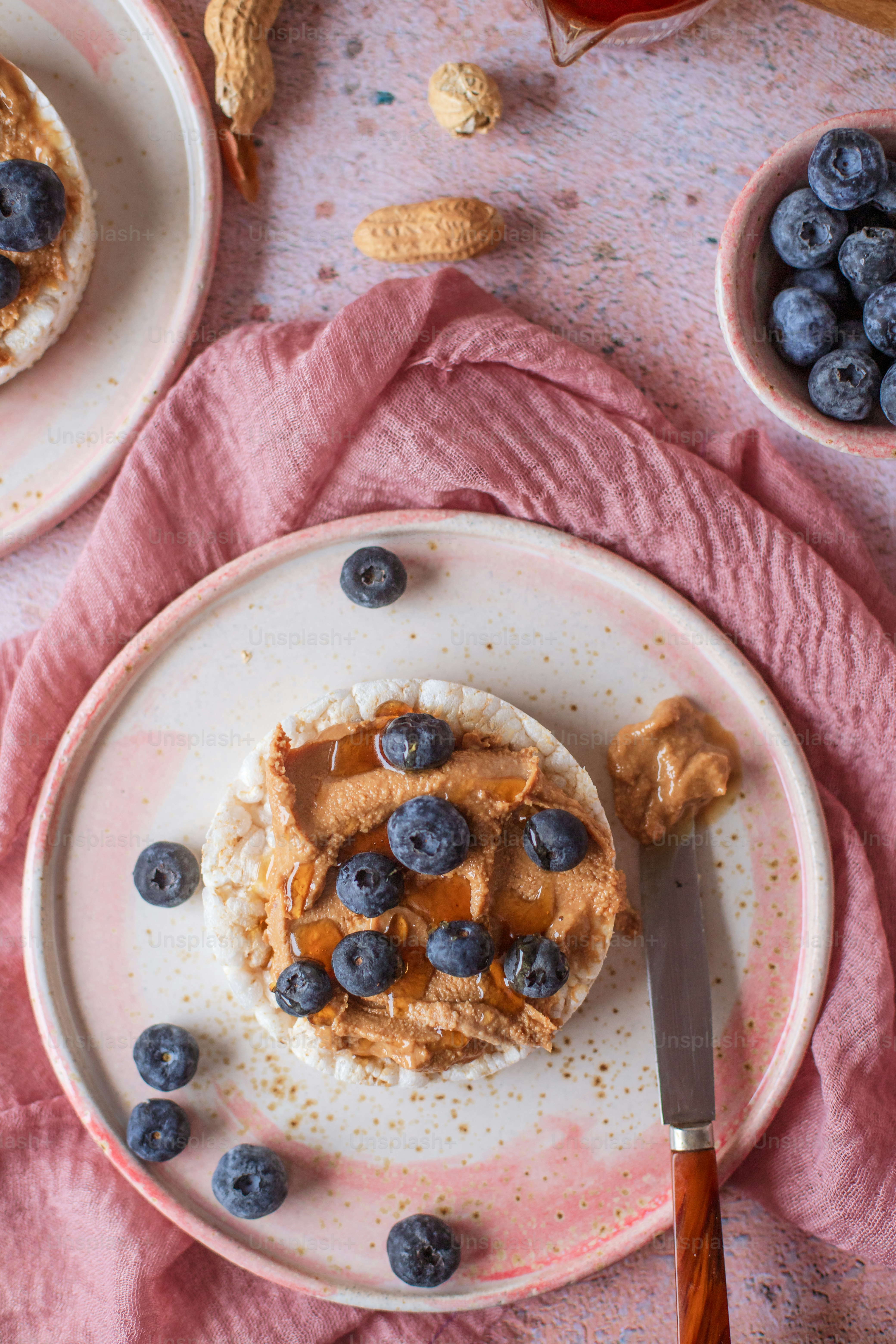 a white plate topped with a piece of cake covered in blueberries