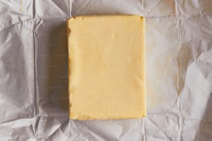ein Stück Käse, das auf einem Stück Wachspapier sitzt