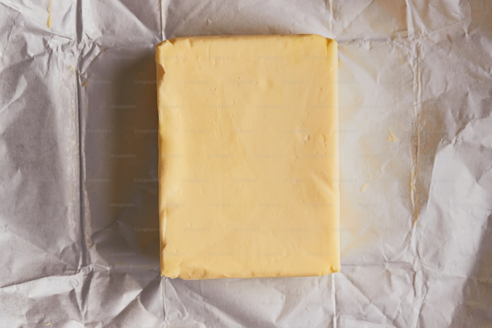 um pedaço de queijo sentado em cima de um pedaço de papel de cera