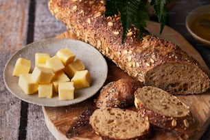 una hogaza de pan, pan de molde y mantequilla en una tabla de cortar