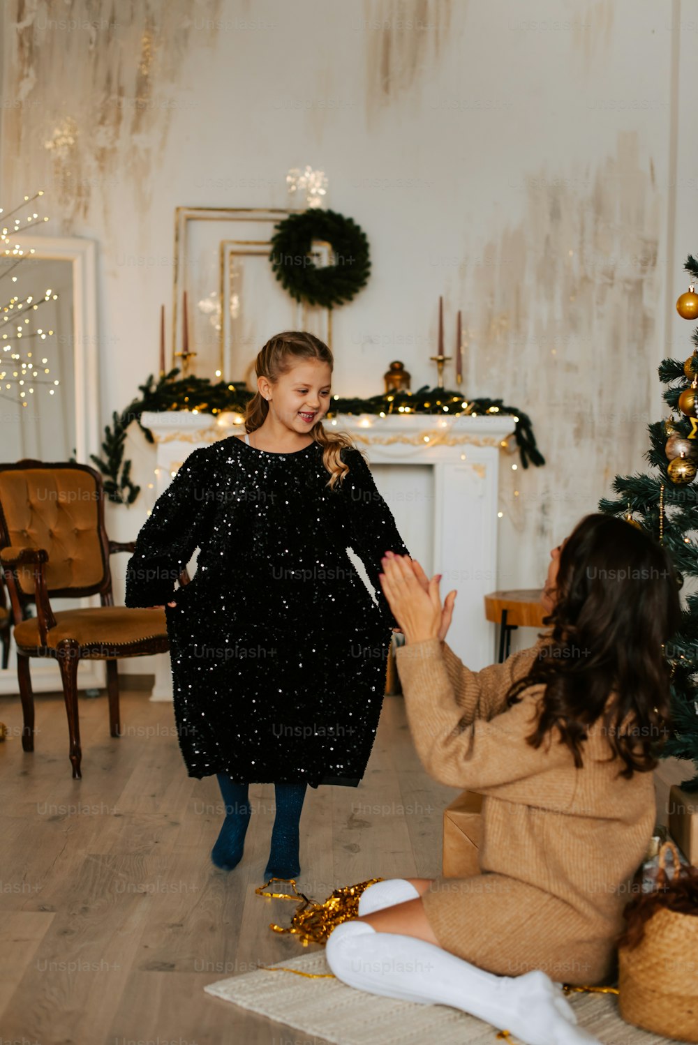 a woman sitting on the floor next to a christmas tree