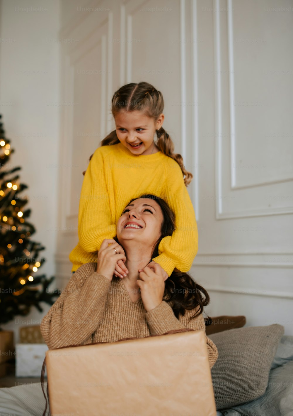 a woman holding a little girl on her shoulders