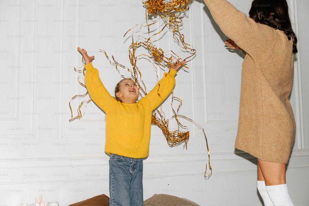 a woman and a child are playing with streamers