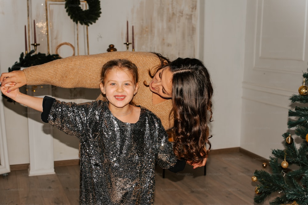 a woman holding a child in front of a christmas tree