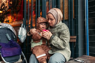 uma mulher sentada em um banco segurando uma criança