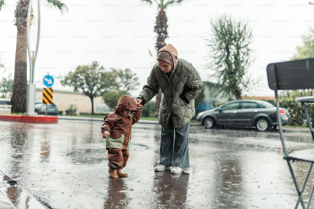 雨の中、子供の手を握る男