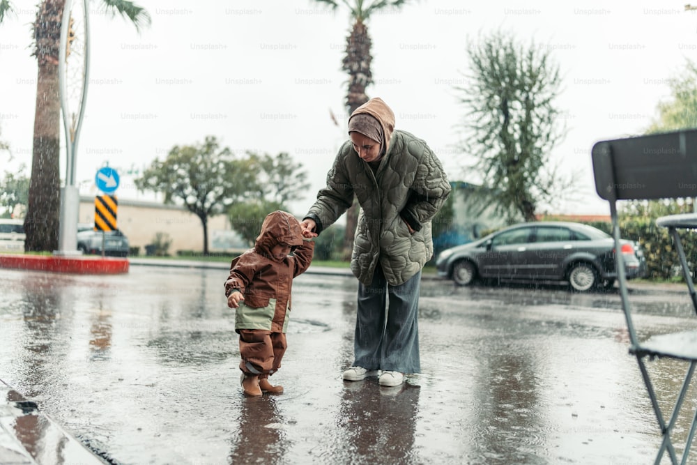 a man holding the hand of a child in the rain