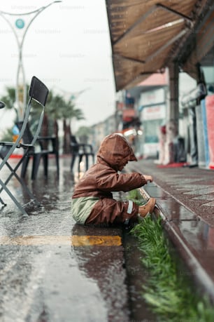 a person sitting on the ground in the rain