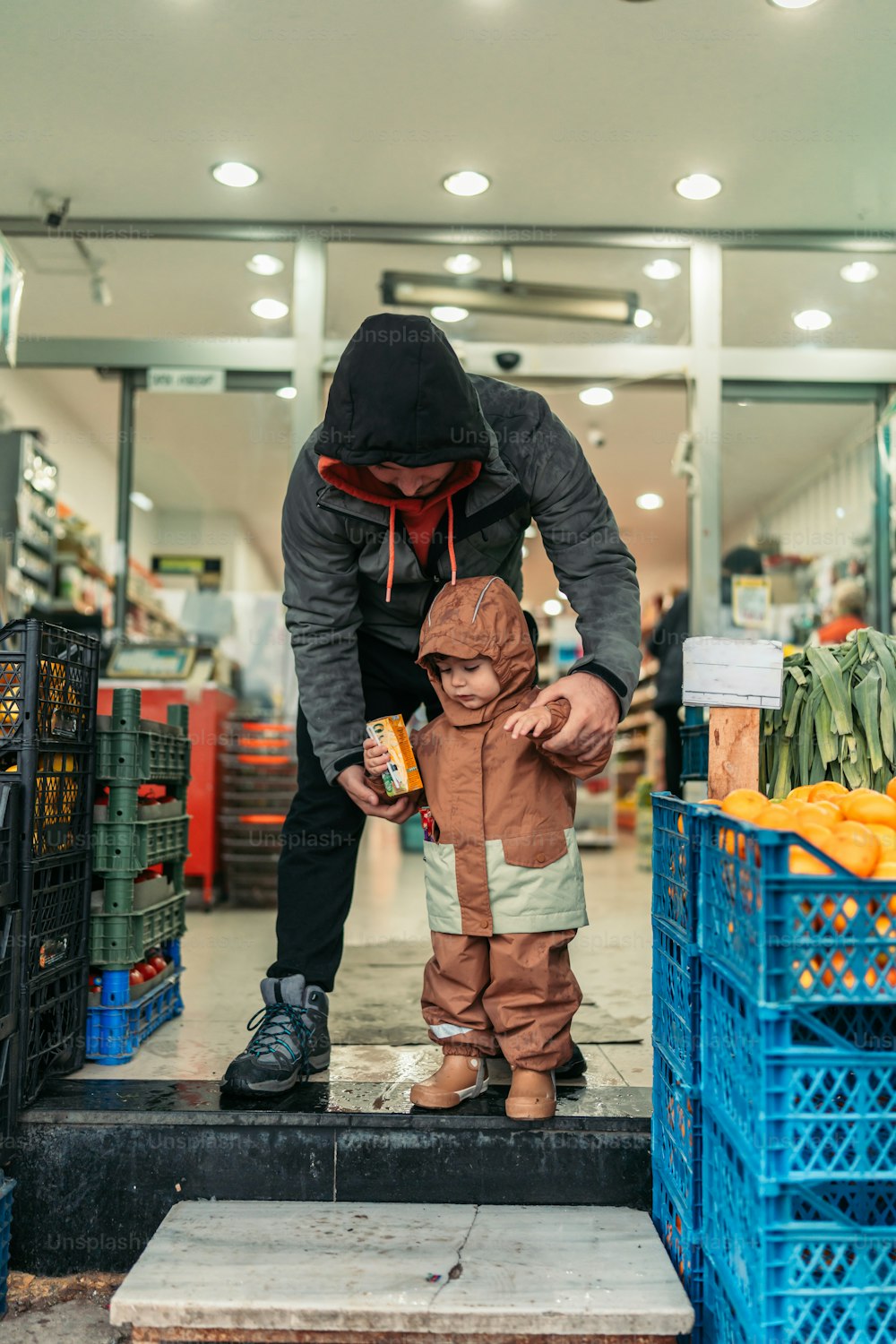 a man in a black hoodie and a child in a brown jacket