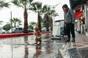 a man standing next to a little boy on a skateboard