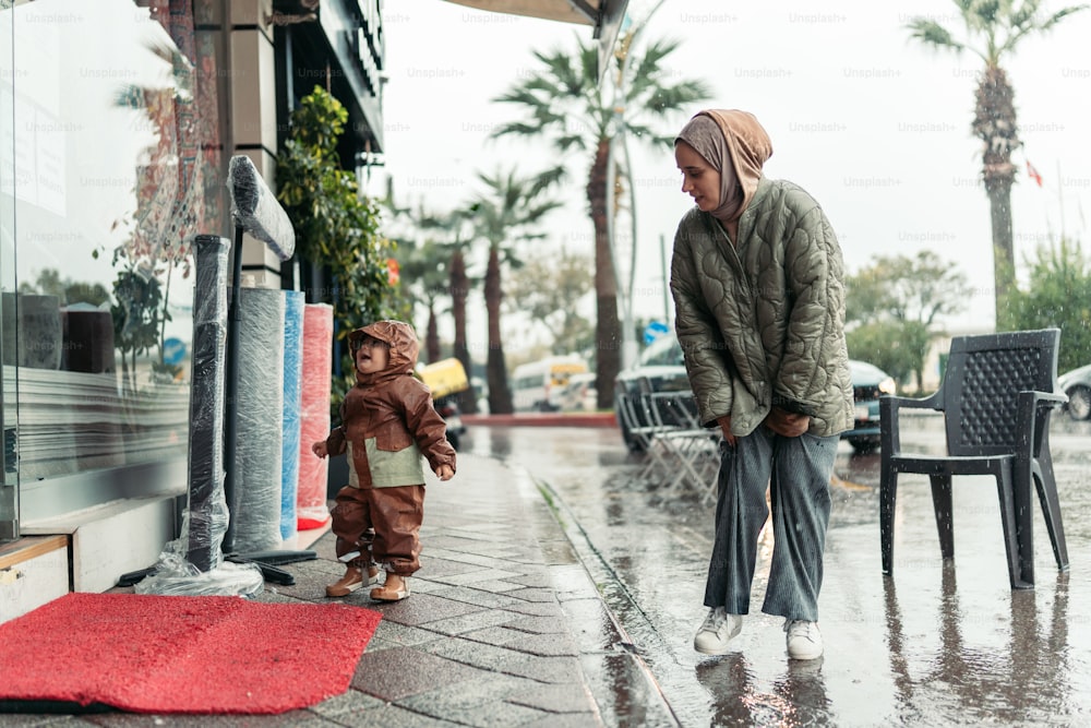 una donna e un bambino che camminano sotto la pioggia