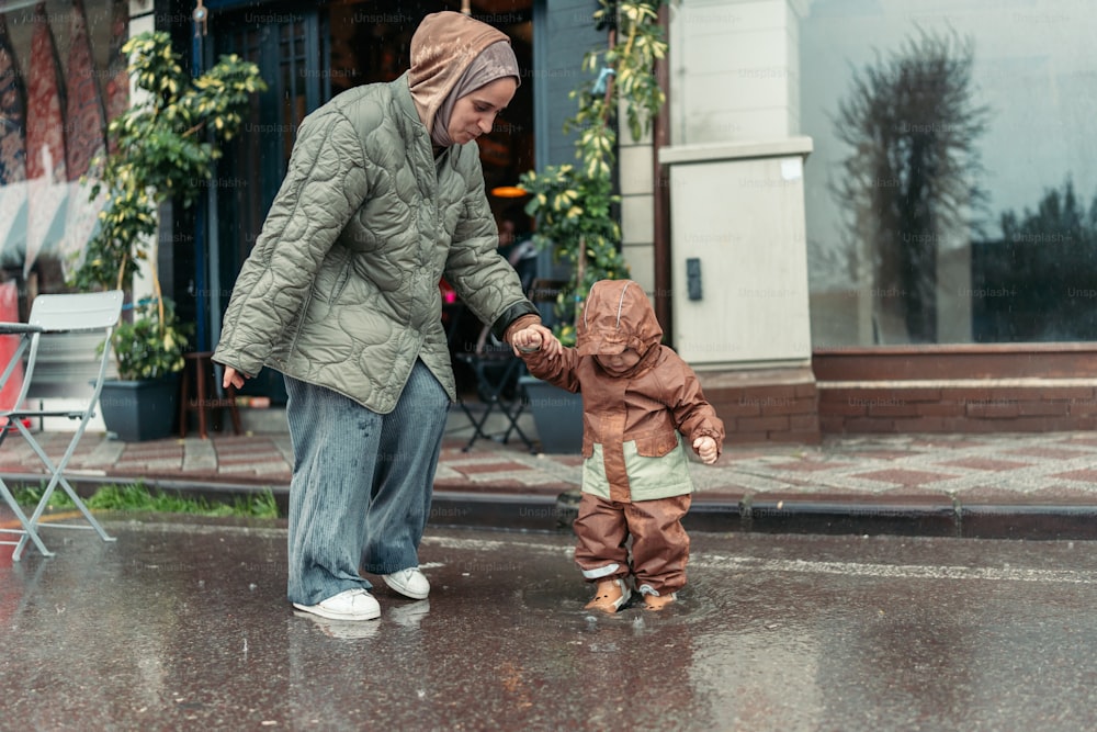 a woman holding the hand of a small child