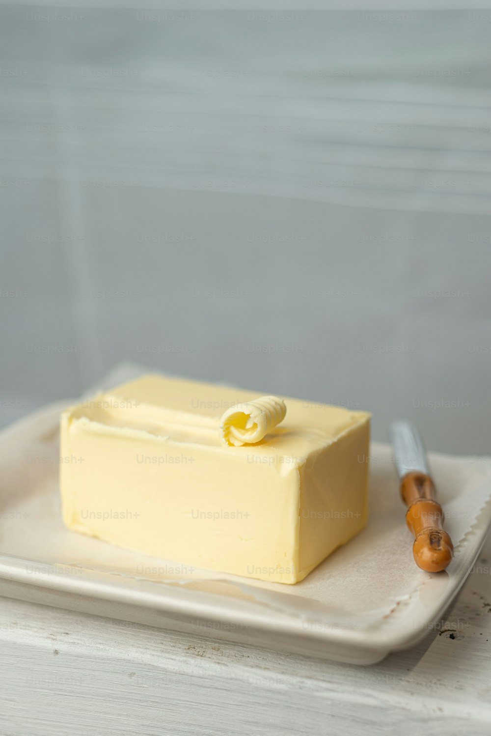 a square piece of yellow cake on a white plate