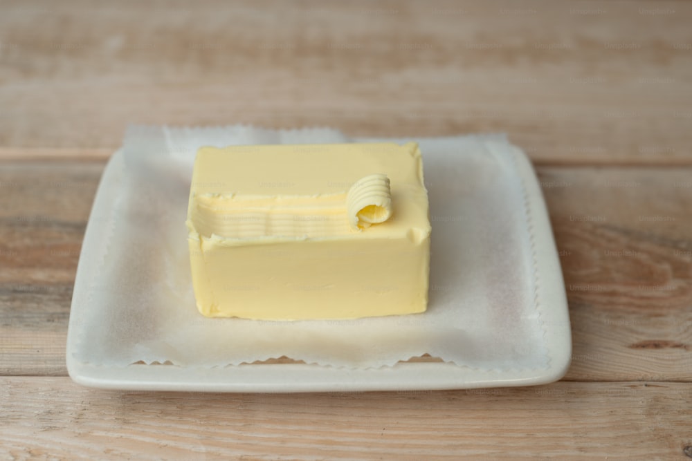白い皿に乗せた四角い黄色いケーキ