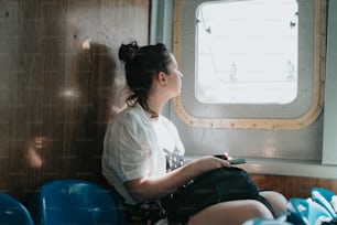 a woman sitting on a boat looking out the window