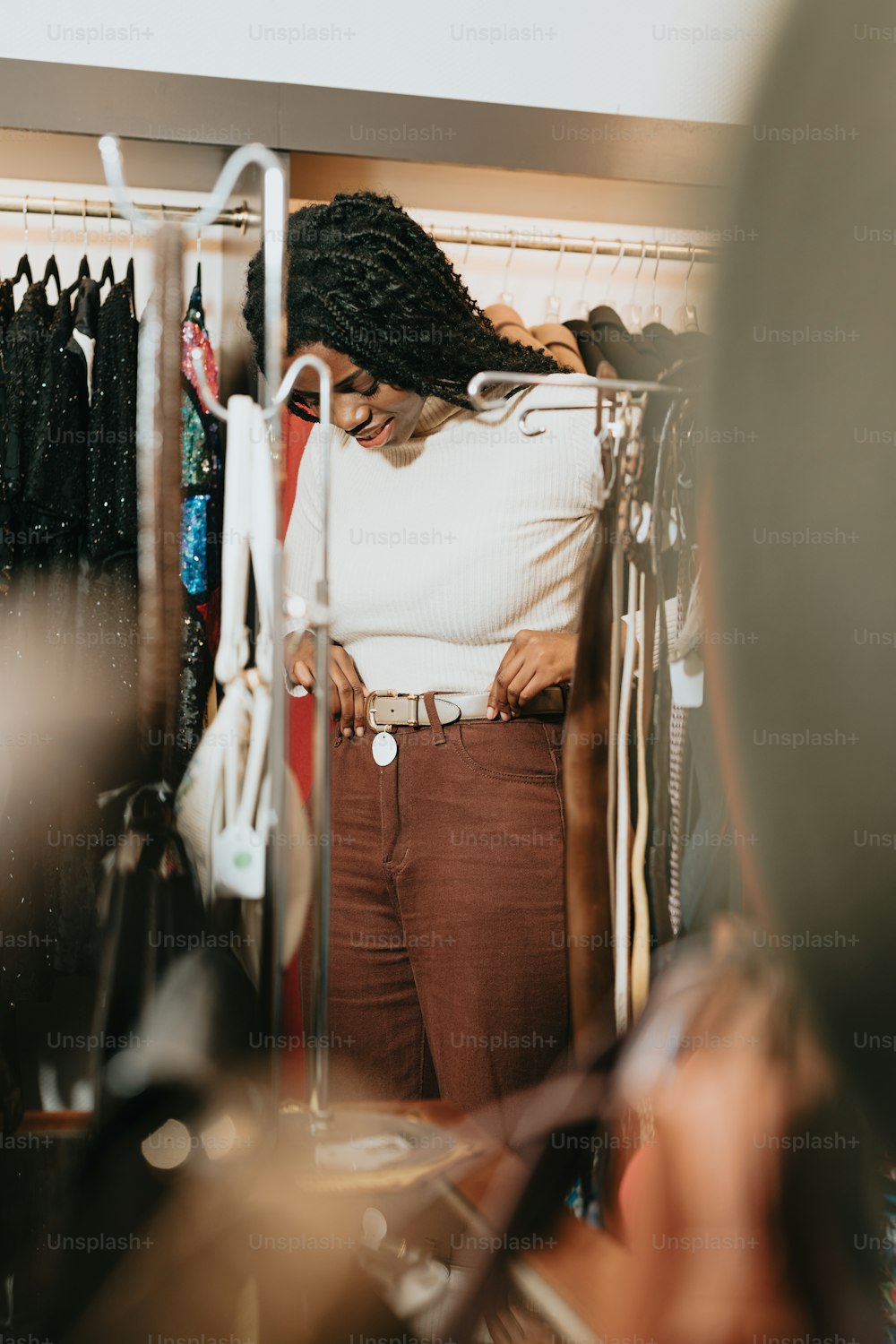 a woman standing in front of a rack of clothes