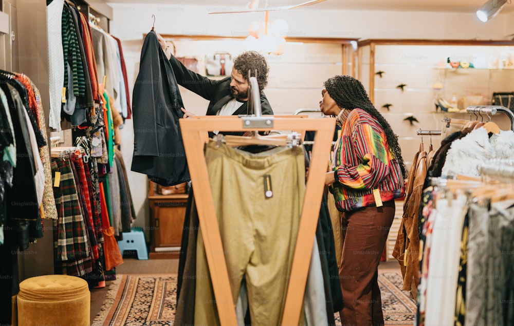 a man and a woman looking at clothes in a store