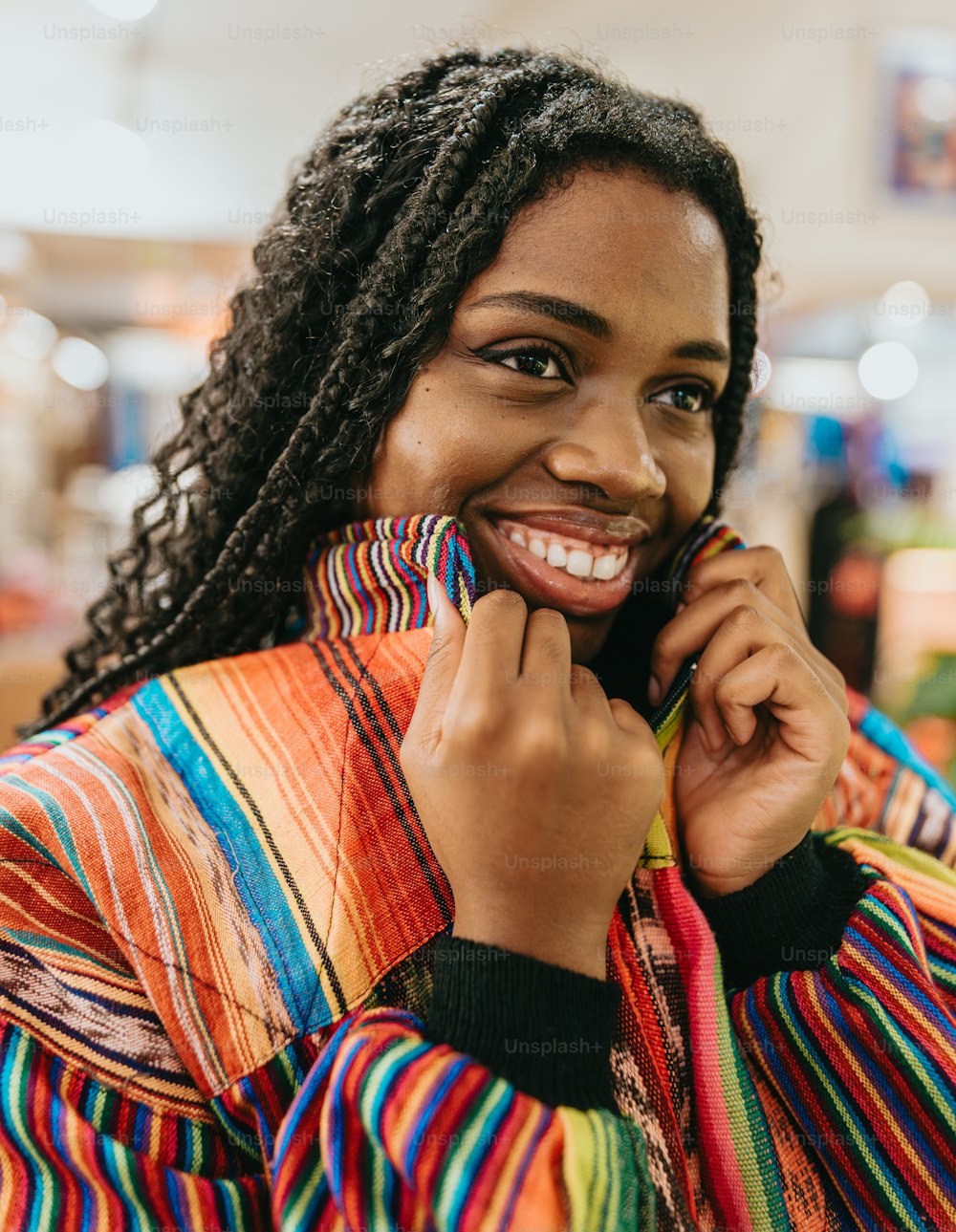 Uma mulher sorri enquanto segura uma jaqueta colorida