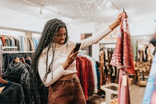 a woman looking at her cell phone in a clothing store