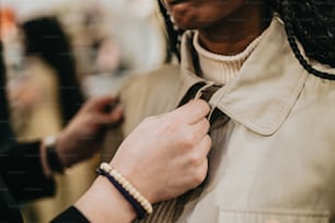 a person tying a tie on another person's neck