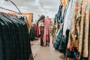 uma mulher está olhando para roupas em uma loja de roupas