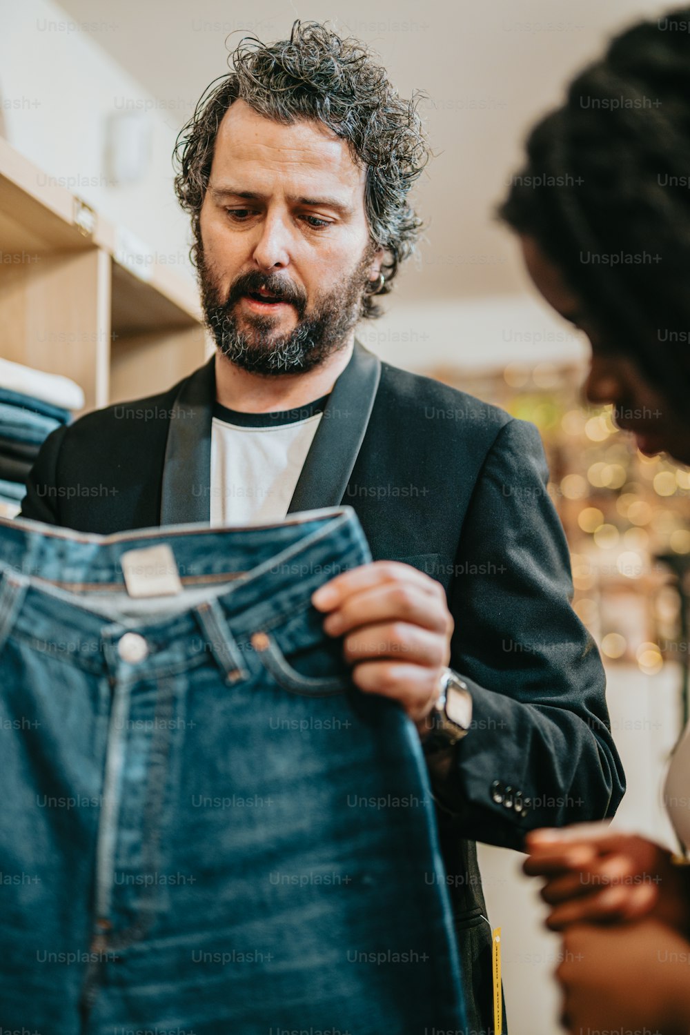 a man looking at a pair of blue jeans