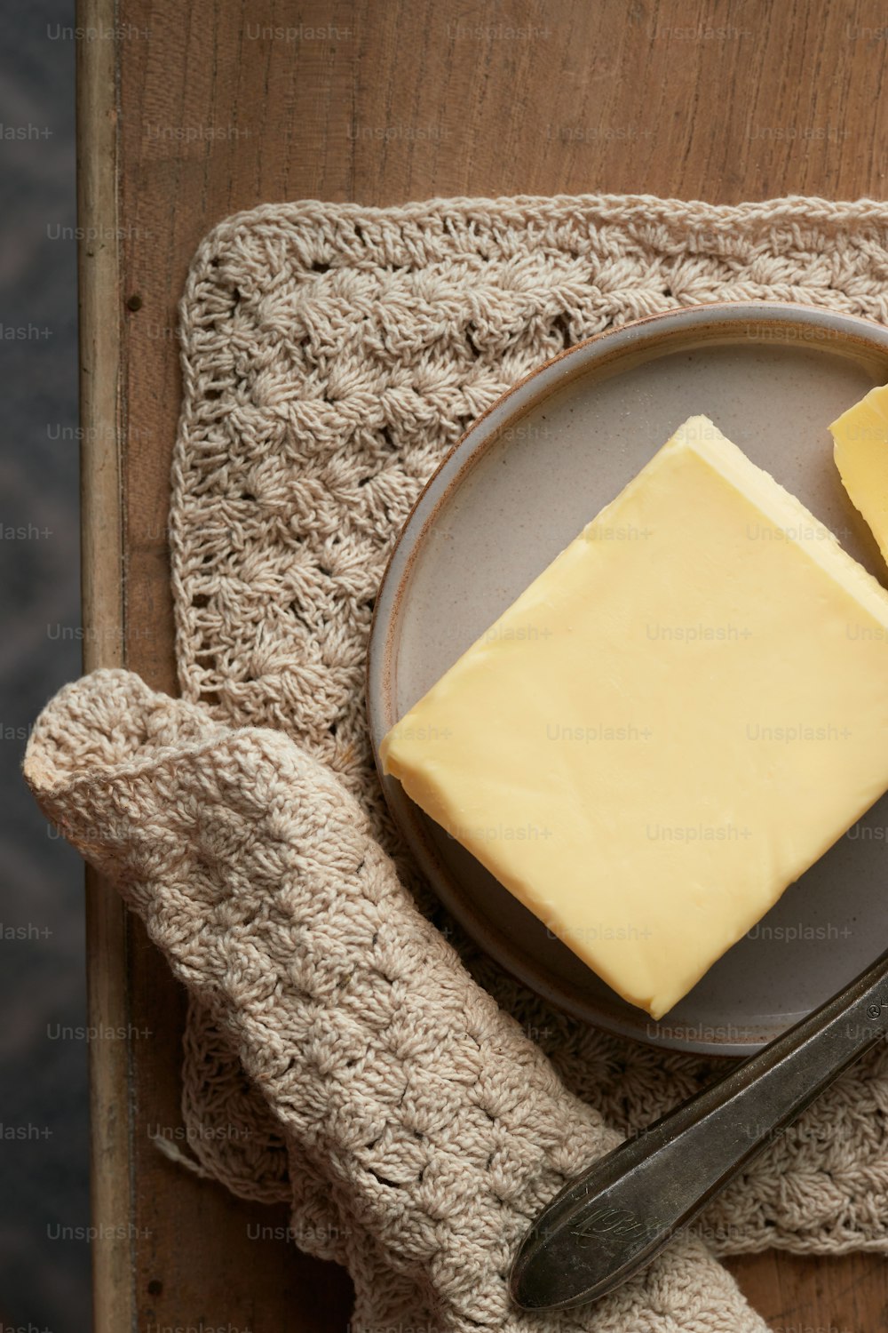 a piece of cheese on a plate next to a knife