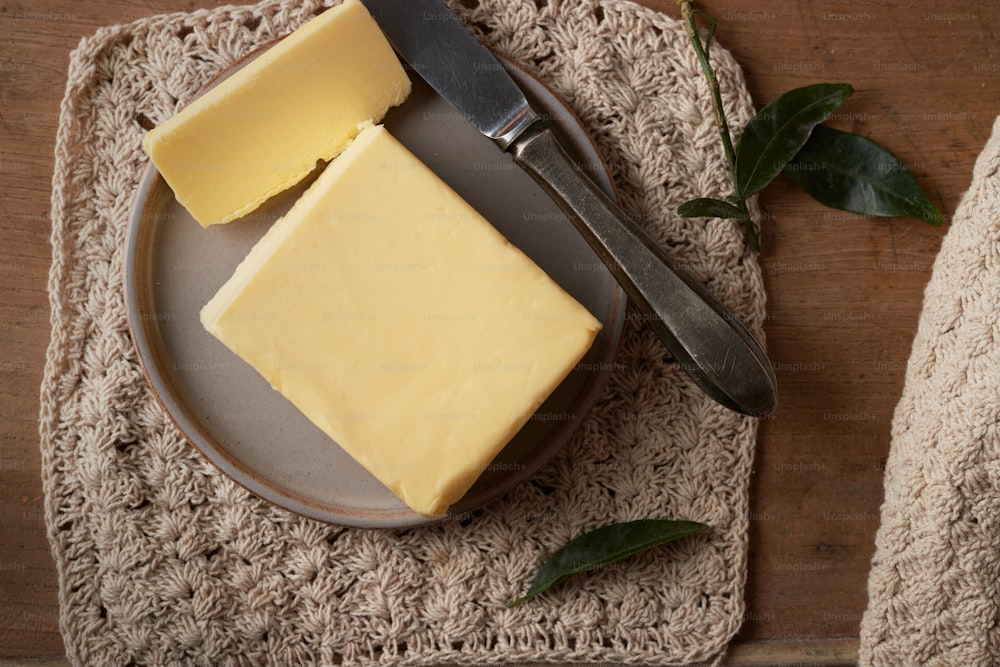 um pedaço de queijo em um prato com uma faca