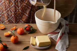una persona che versa il formaggio in una ciotola con arance intorno