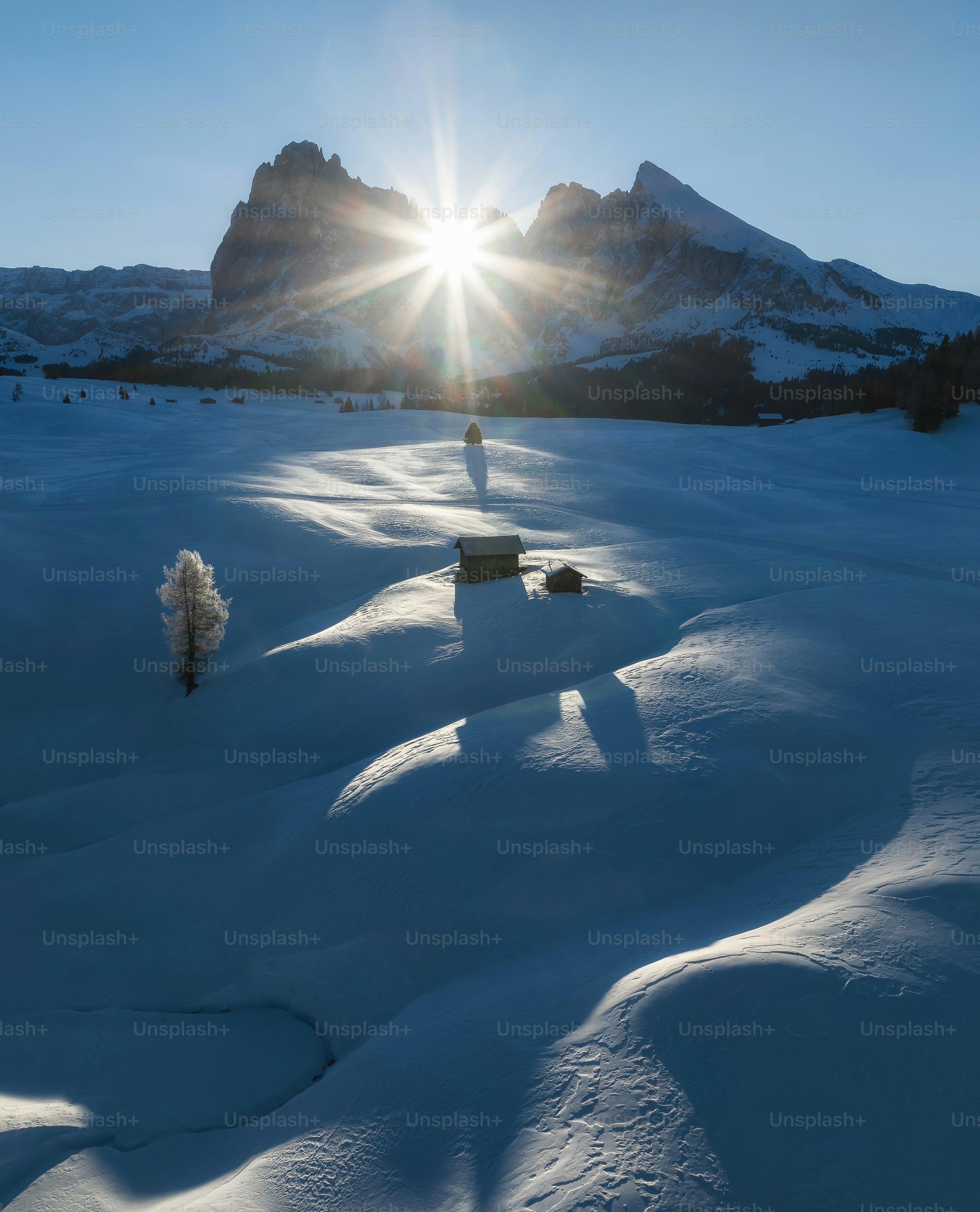 the sun shines brightly over a snowy landscape