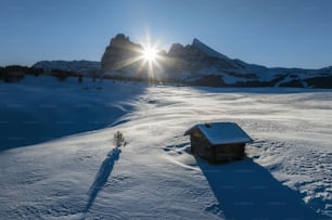 a small cabin in the middle of a snowy field