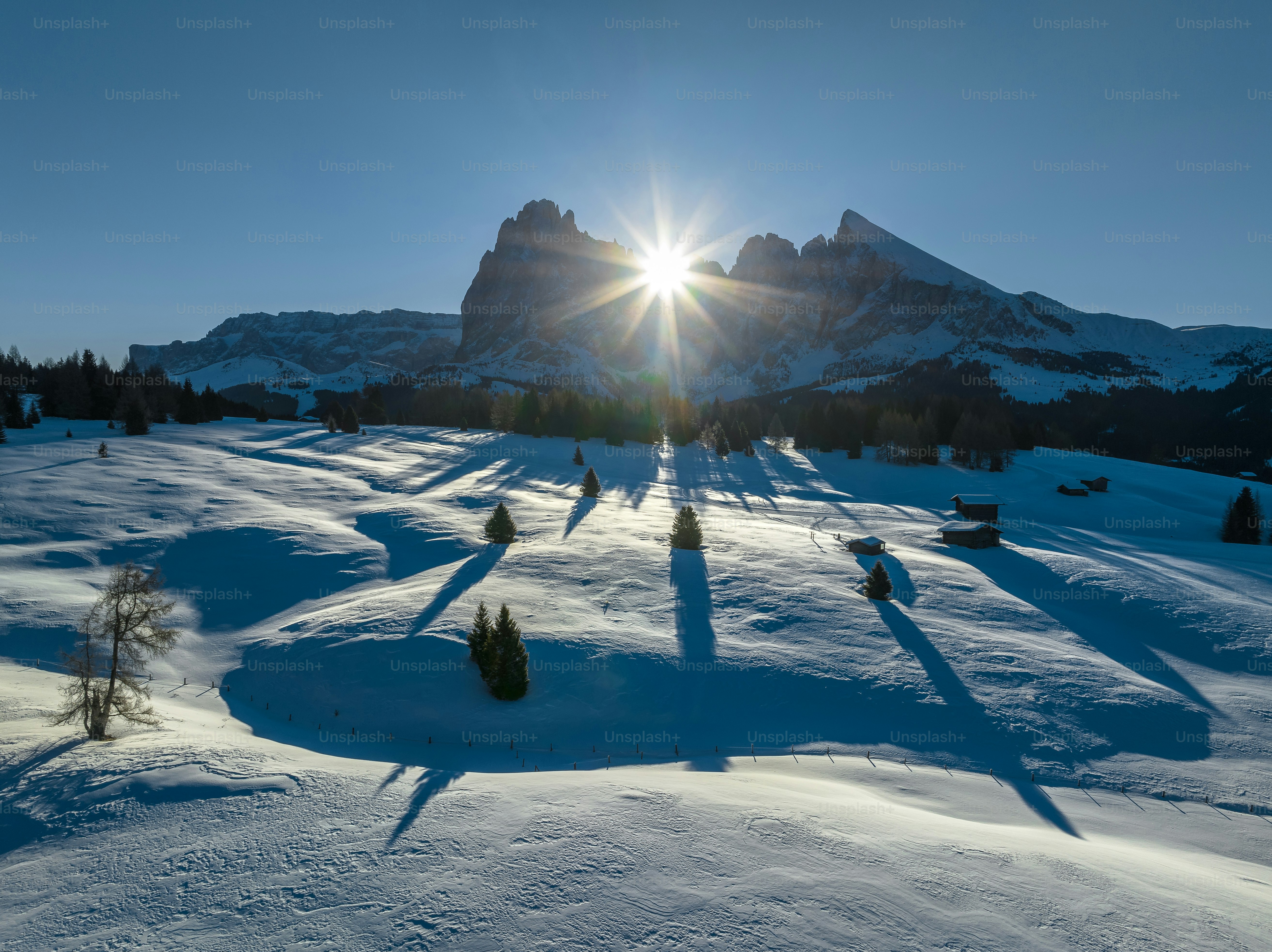 the sun shines brightly over a snowy landscape