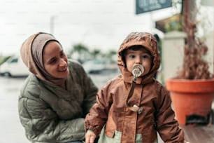 a woman sitting next to a child on a sidewalk