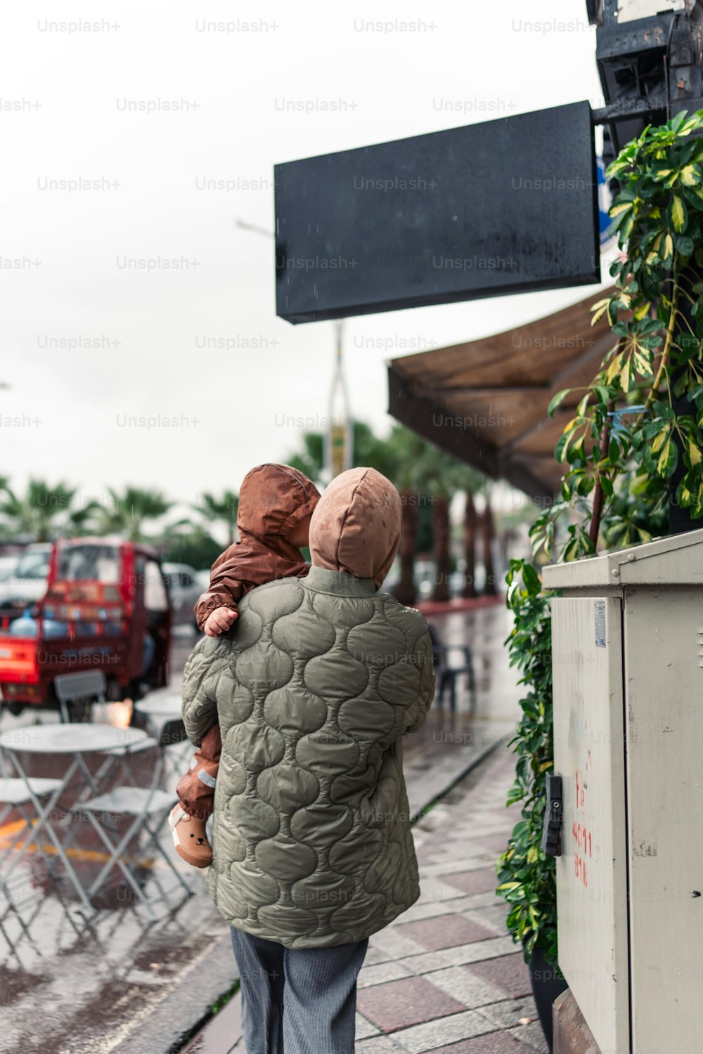 ein Mann mit einem Kind, das einen Bürgersteig entlanggeht
